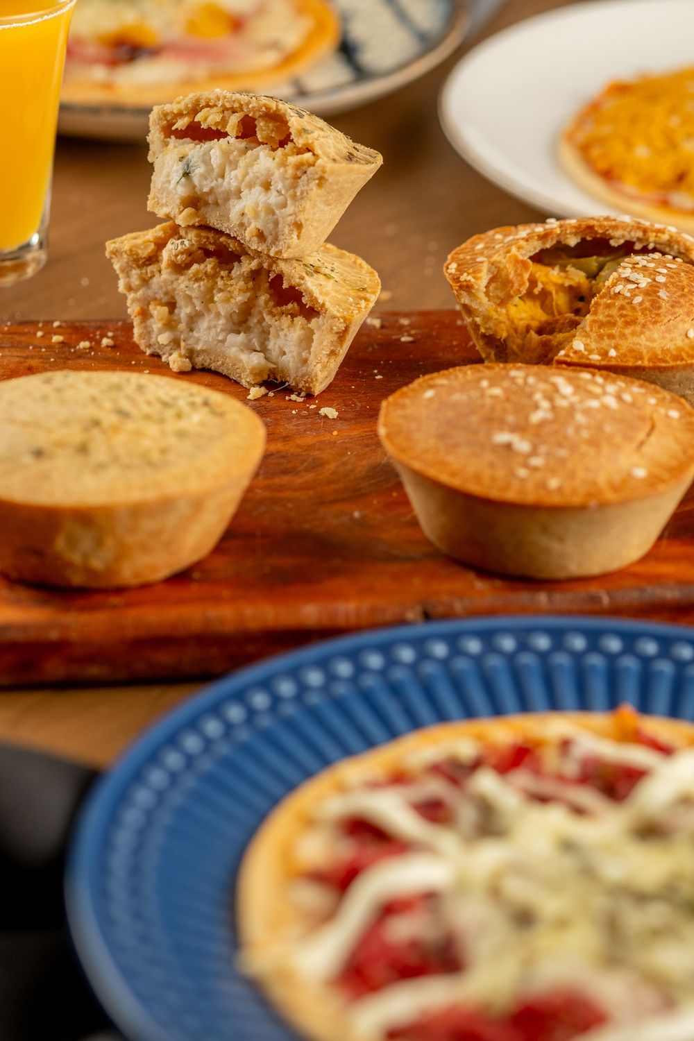 Variedade de empadas, pães e pizzas da Sabor Fit sobre a mesa